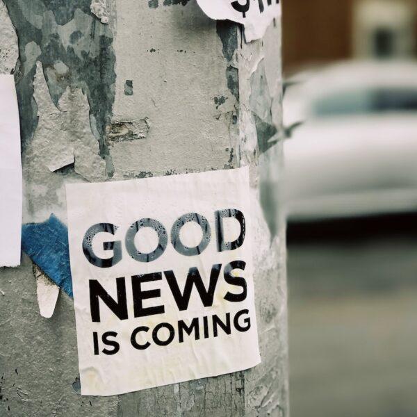 white Good News Is Coming paper on wall